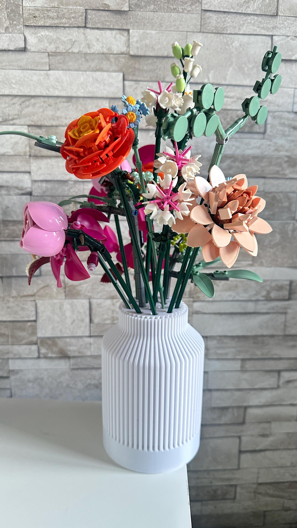 Bouquet de fleurs LEGO® maintenu droit dans le vase bouteille cannelé blanc