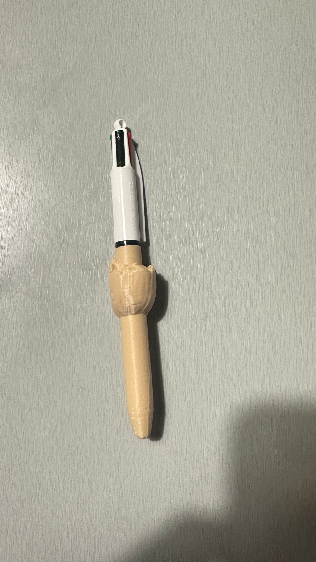 Stylo avec figurine beige, vue de profil