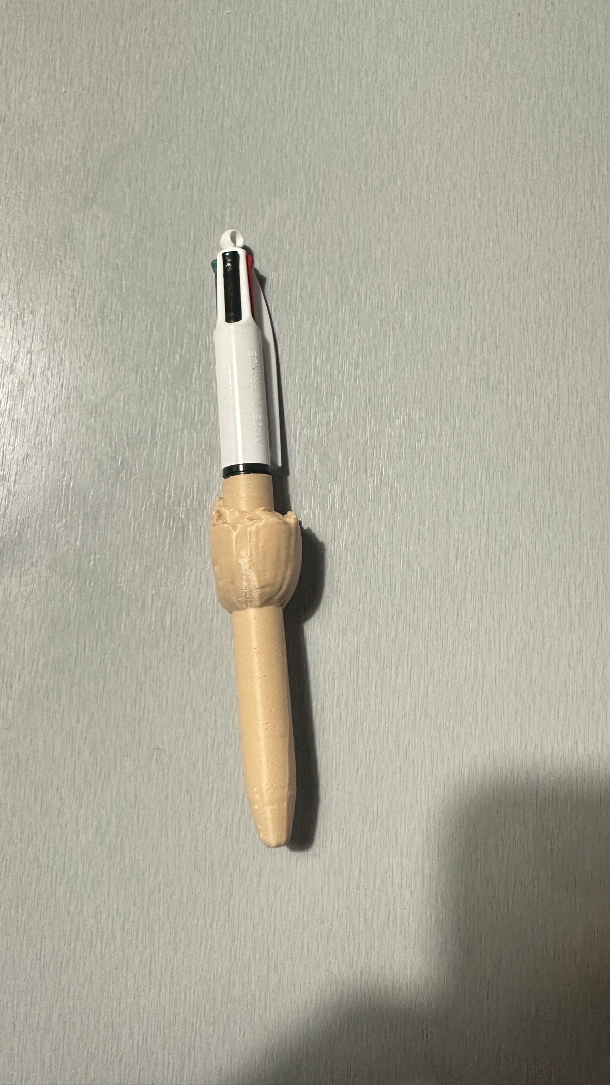 Stylo avec figurine beige, vue de profil