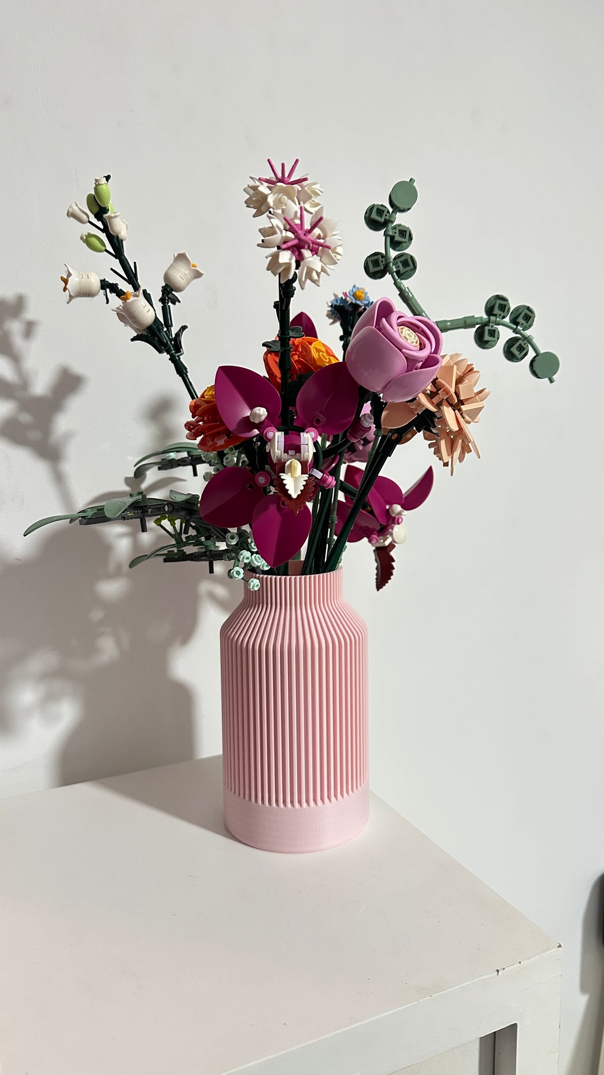 Vase bouteille cannelé rose avec bouquet de fleurs LEGO®