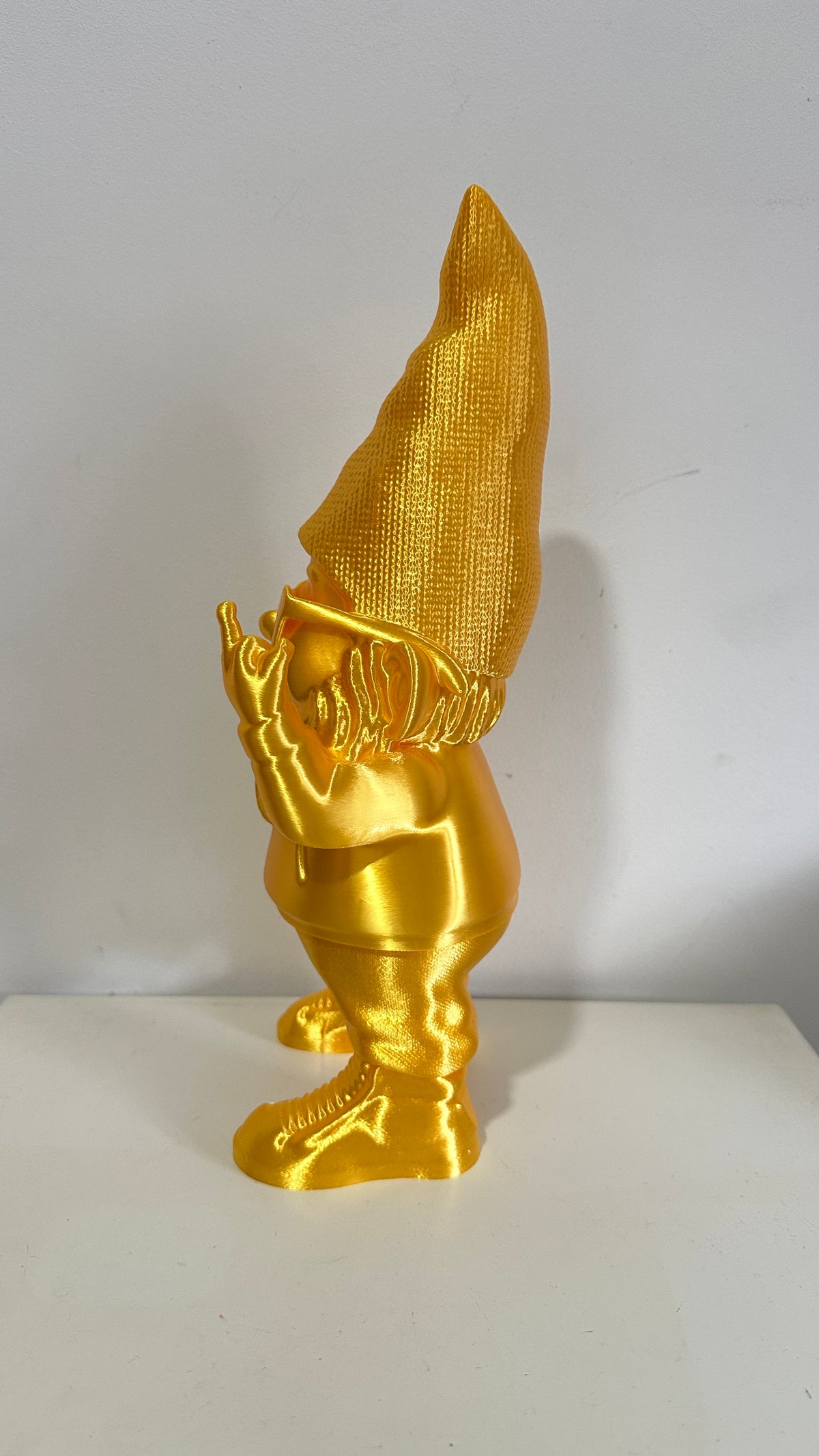 Nain décoratif doré humoristique faisant un doigt d’honneur, vue de dos