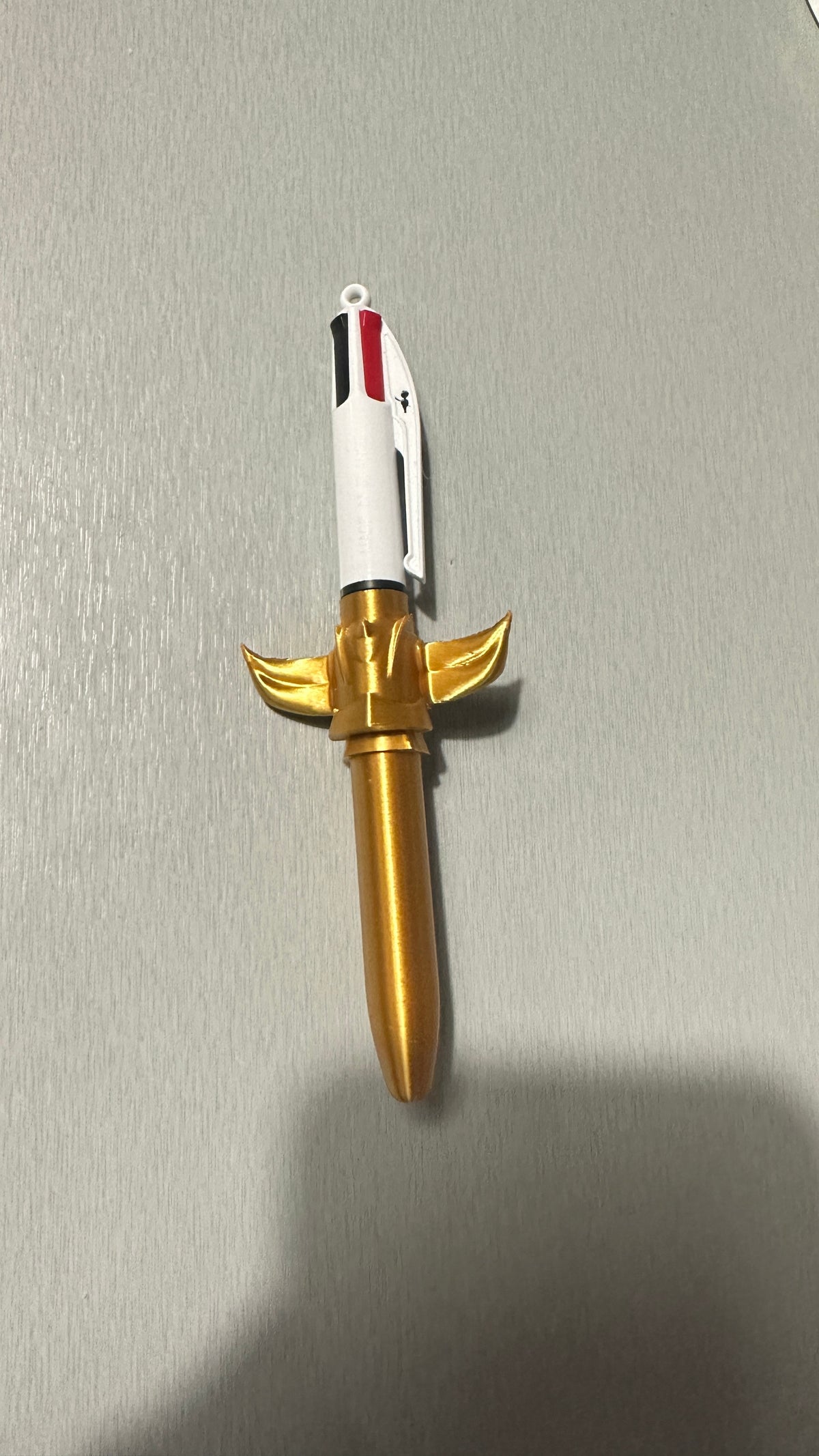 Stylo avec figurine dorée, vue de profil