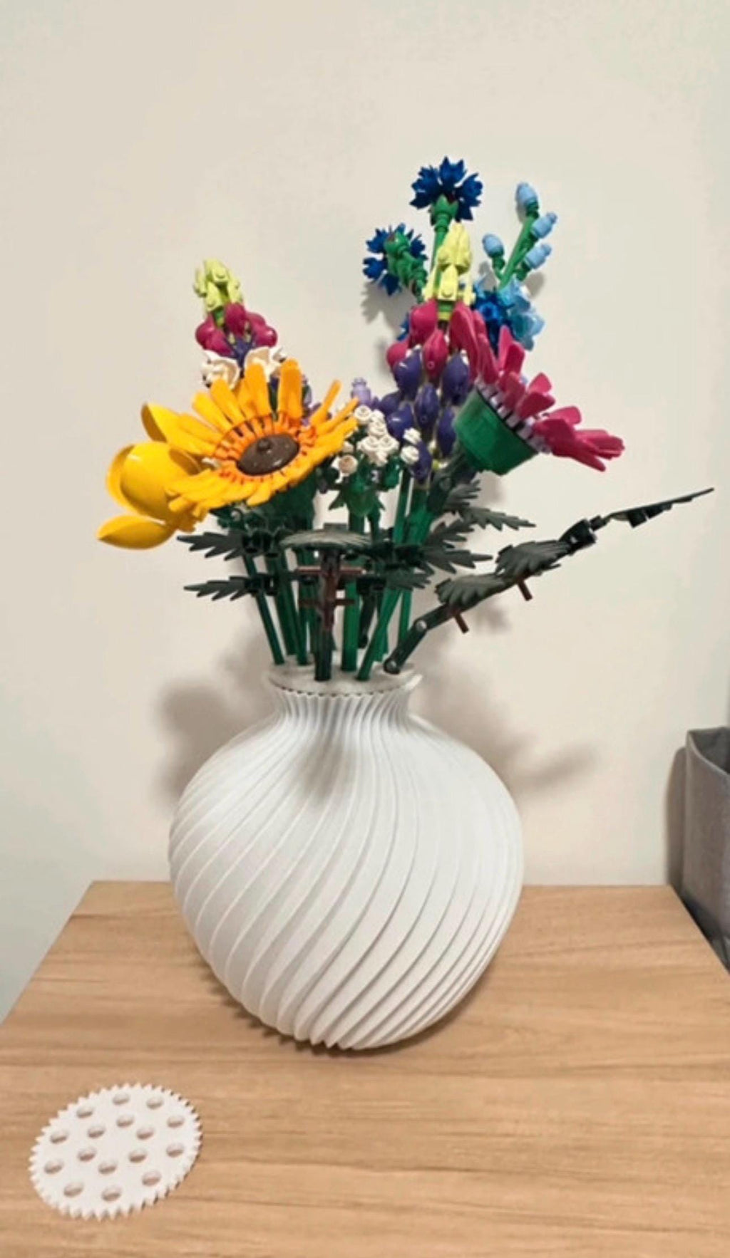 Vase boule torsadé blanc avec bouquet de fleurs sauvages LEGO® et son disque support