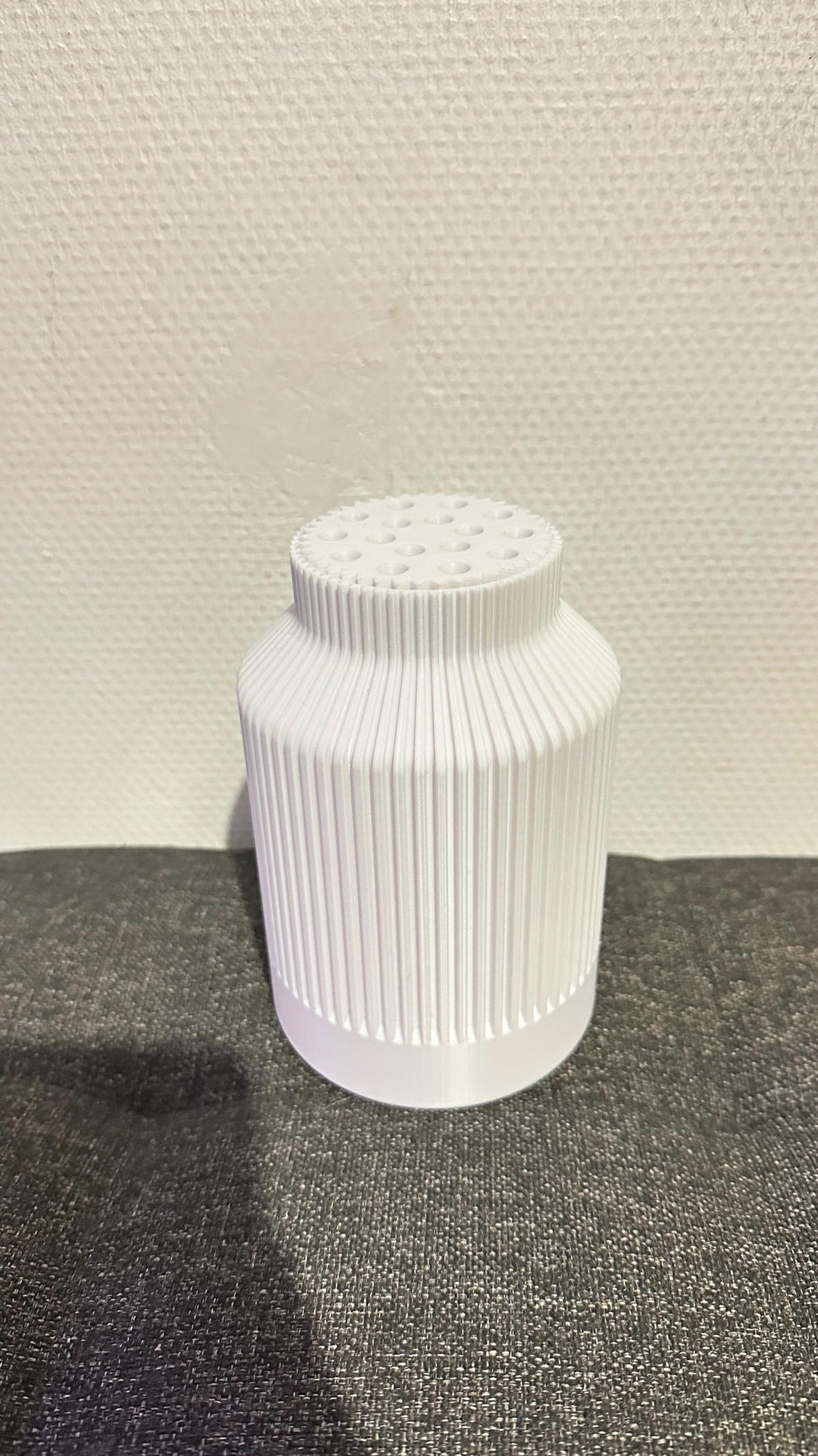 Vase bouteille cannelé blanc vu sans fleurs, avec son support de tiges intégré