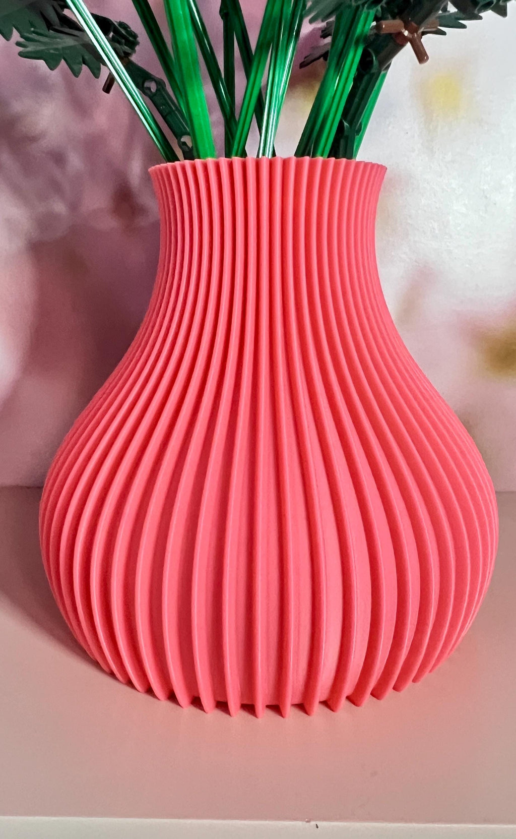 Gros plan sur les cannelures du vase rose corail imprimé en 3D