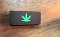 Boîte de rangement noire fermée avec logo vert sur le couvercle