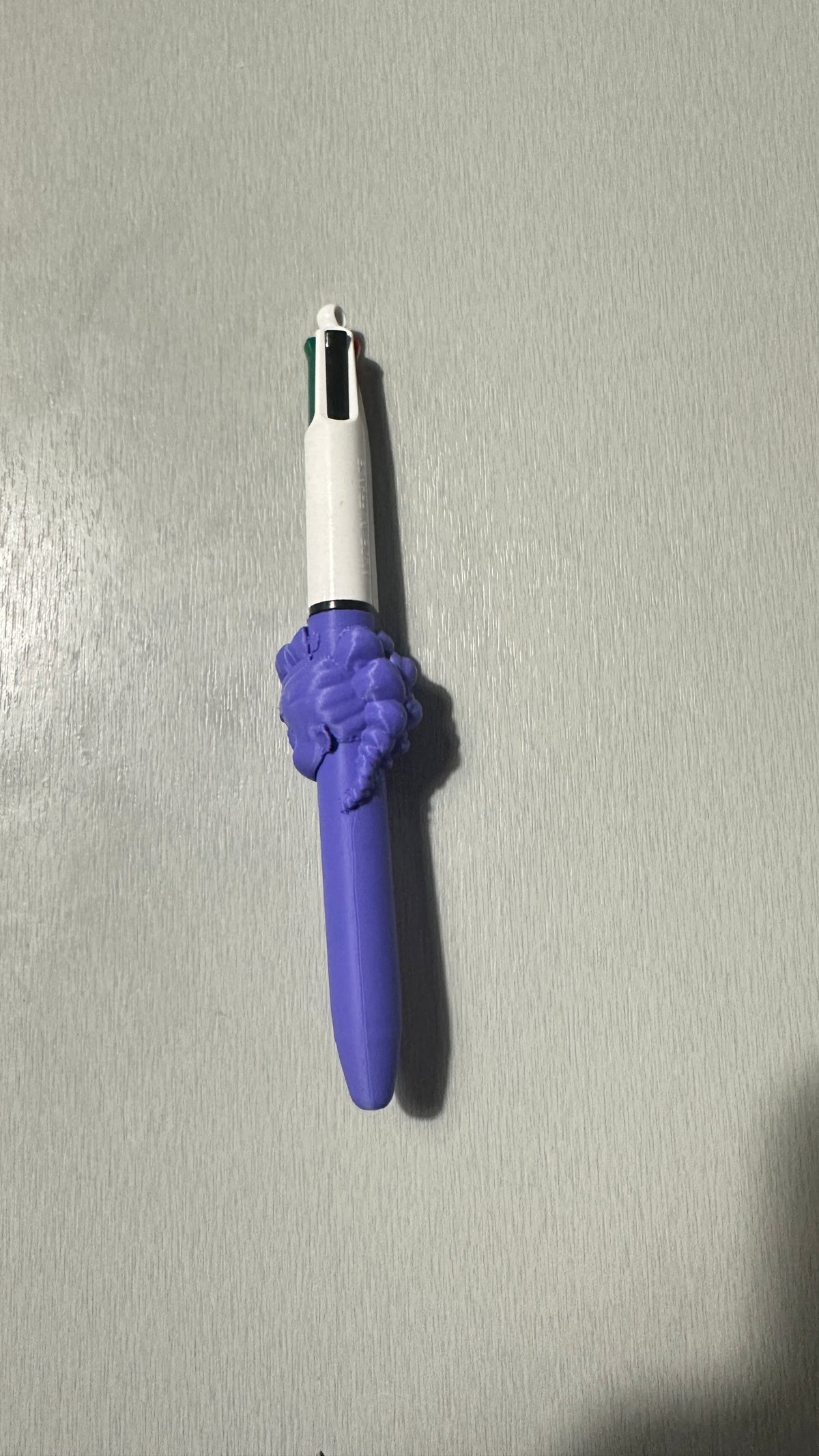 Stylo avec figurine violette, vue de profil