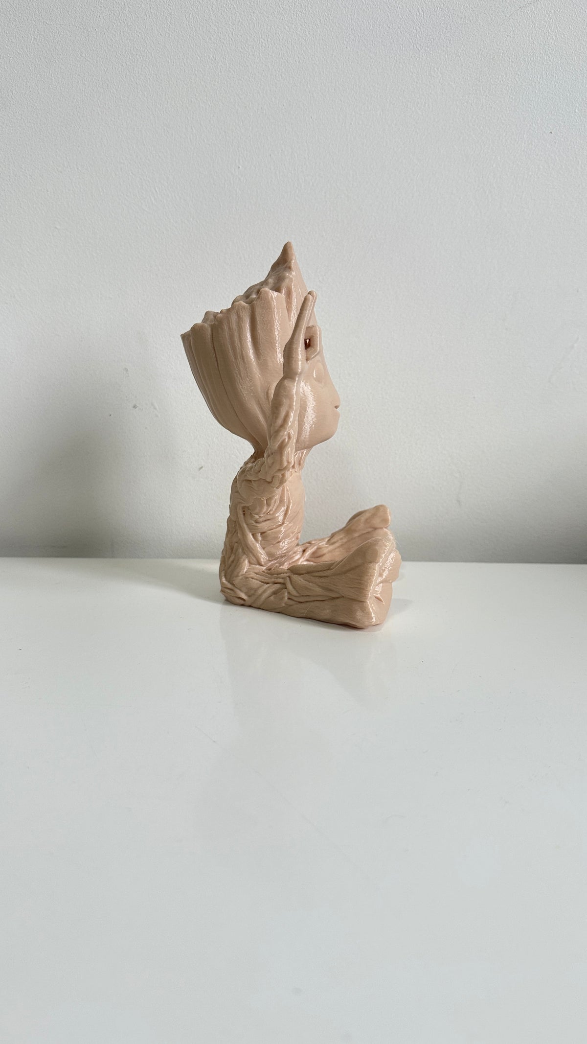 Figurine petit arbre beige bras levés, vue de profil