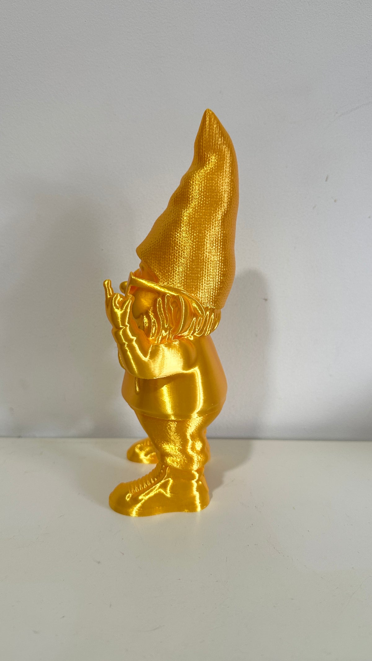 Nain décoratif doré humoristique faisant un doigt d’honneur, vue de trois quarts