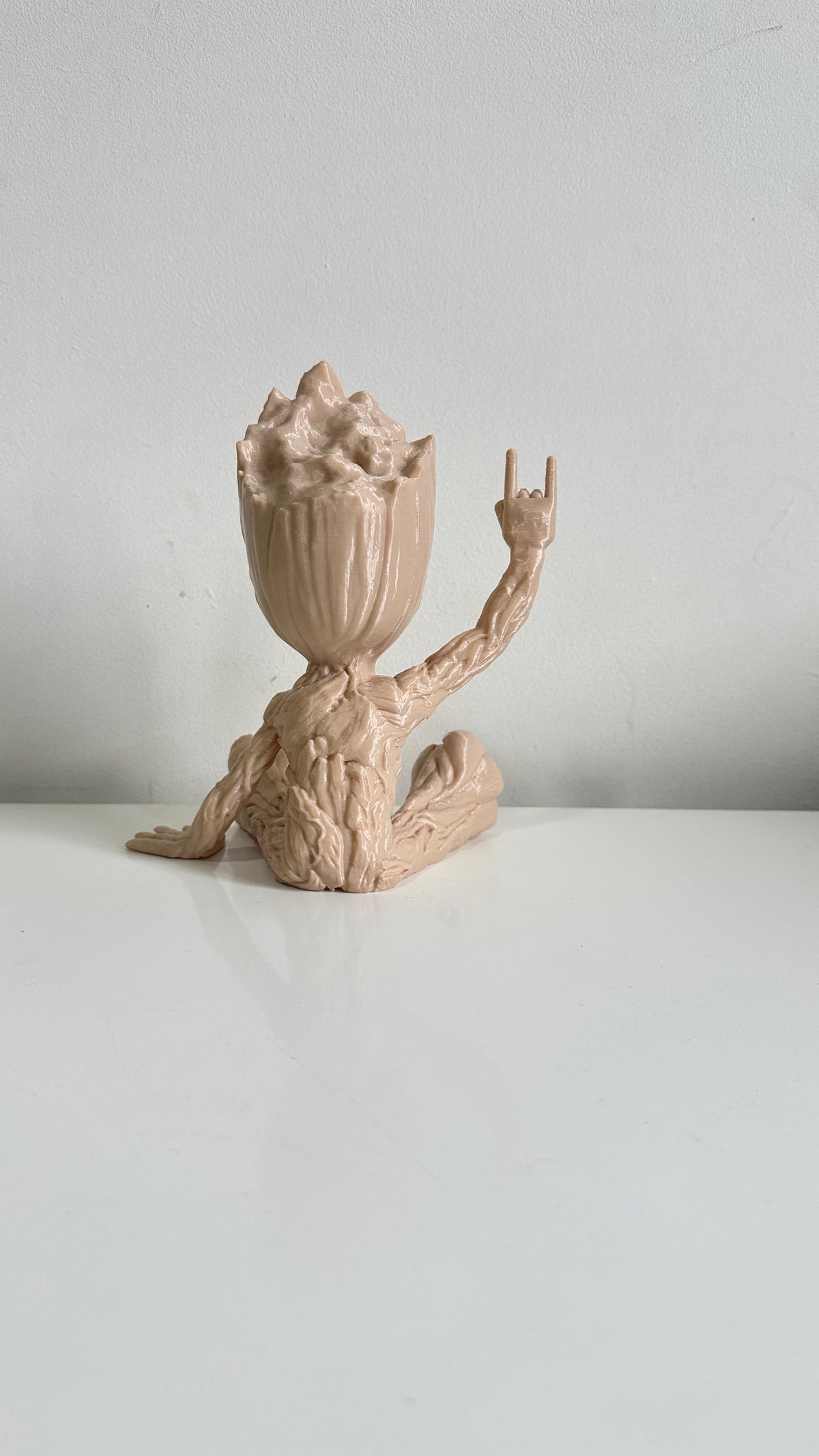 Figurine petit arbre beige bras levés, vue de trois quarts