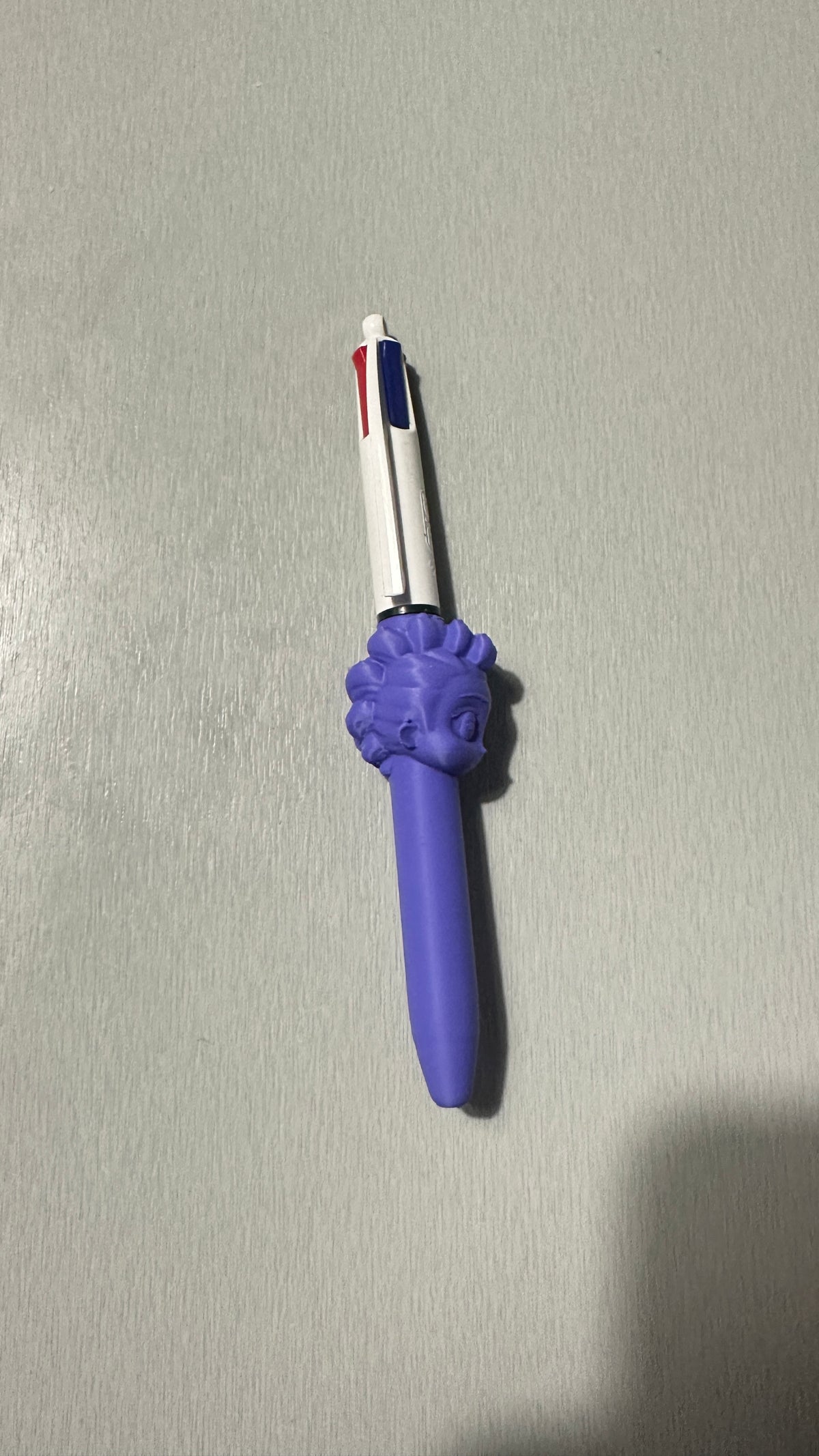 Stylo avec figurine violette, vue de face
