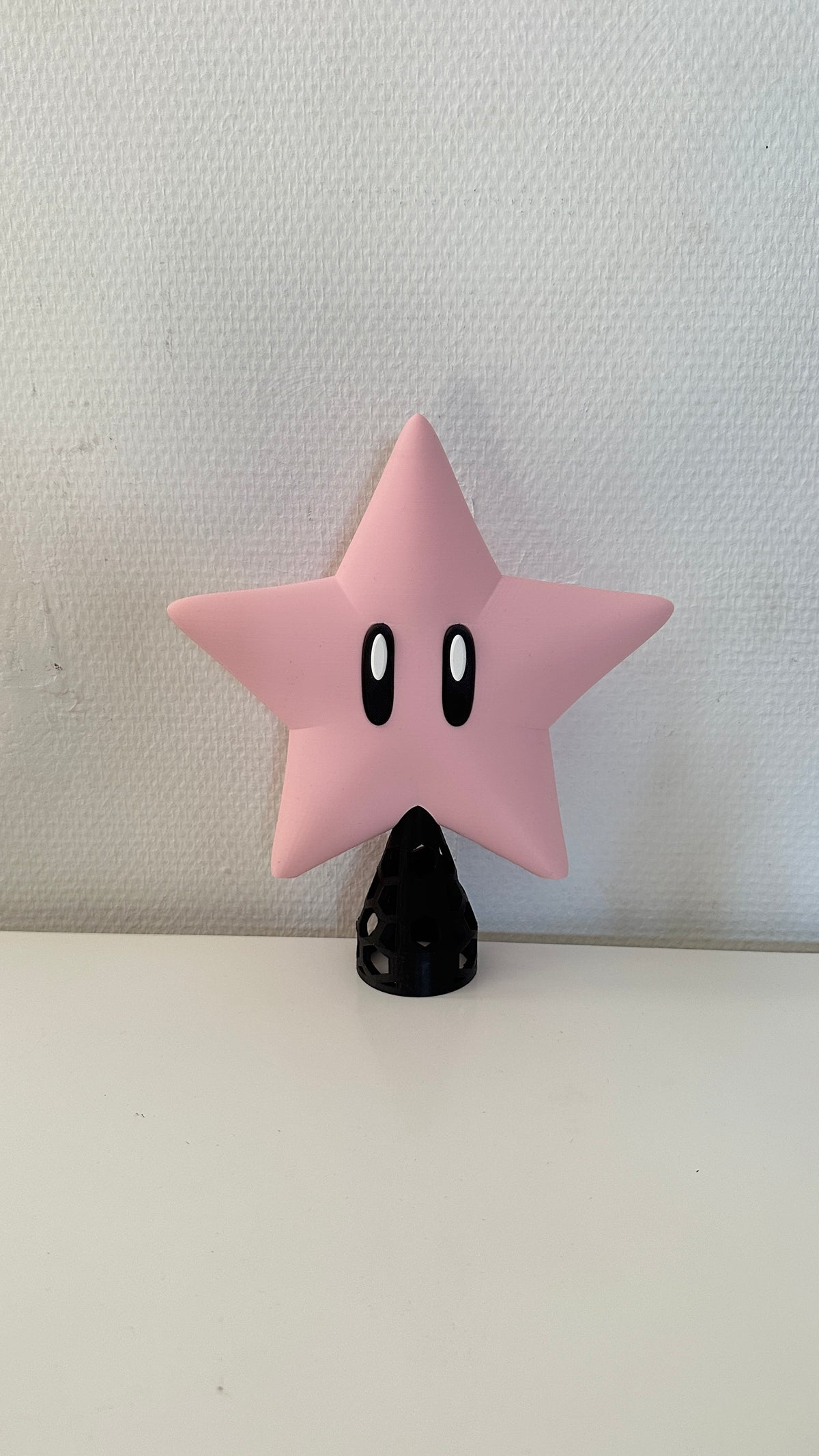 Étoile à grands yeux rose sur son support